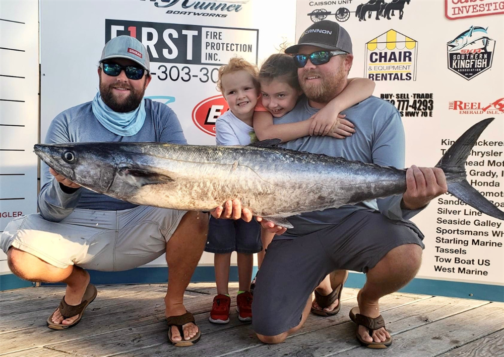 Josh Henderson posing with his children and brother, Crockett, during a fishing tournament post-weigh-in photo. 